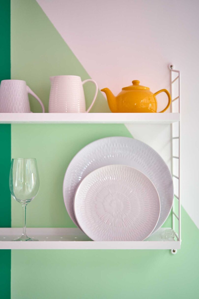 closeup view of white wall shelf in kitchen holding dishes
