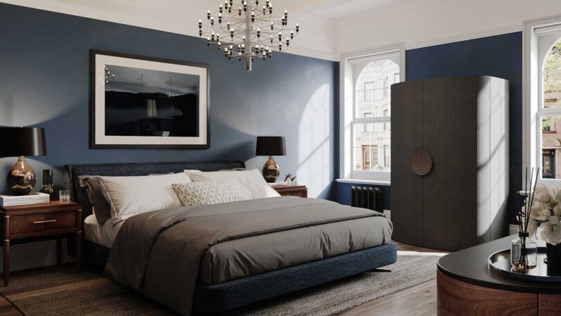 modern bedroom with dark blue walls with black cabinet closed hiding a work from home office setup