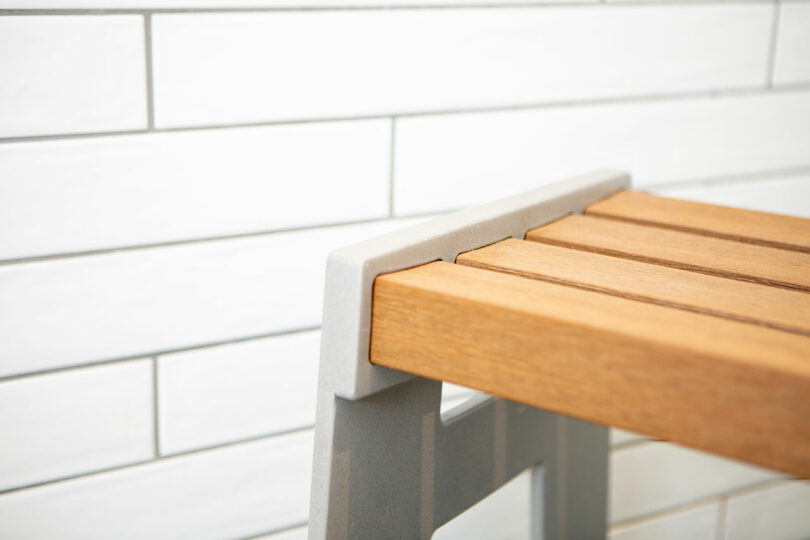 closeup angled view of modern shower seat with wood seat