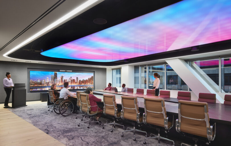 employees having a meeting under a color-changing ceiling in a conference room