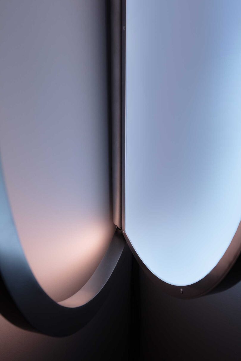 detail of an oval-shaped wall light that resembles a window when illuminated