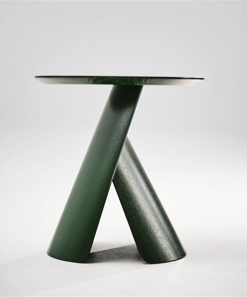 green wooden coffee table with rounded top and molded base