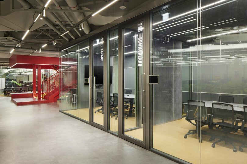 Modern office meeting room with glass walls and interior lighting.