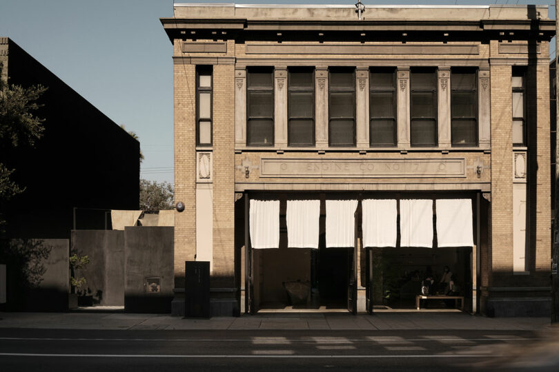 Historic firehouse façade with open bay doors revealing modern interior use.