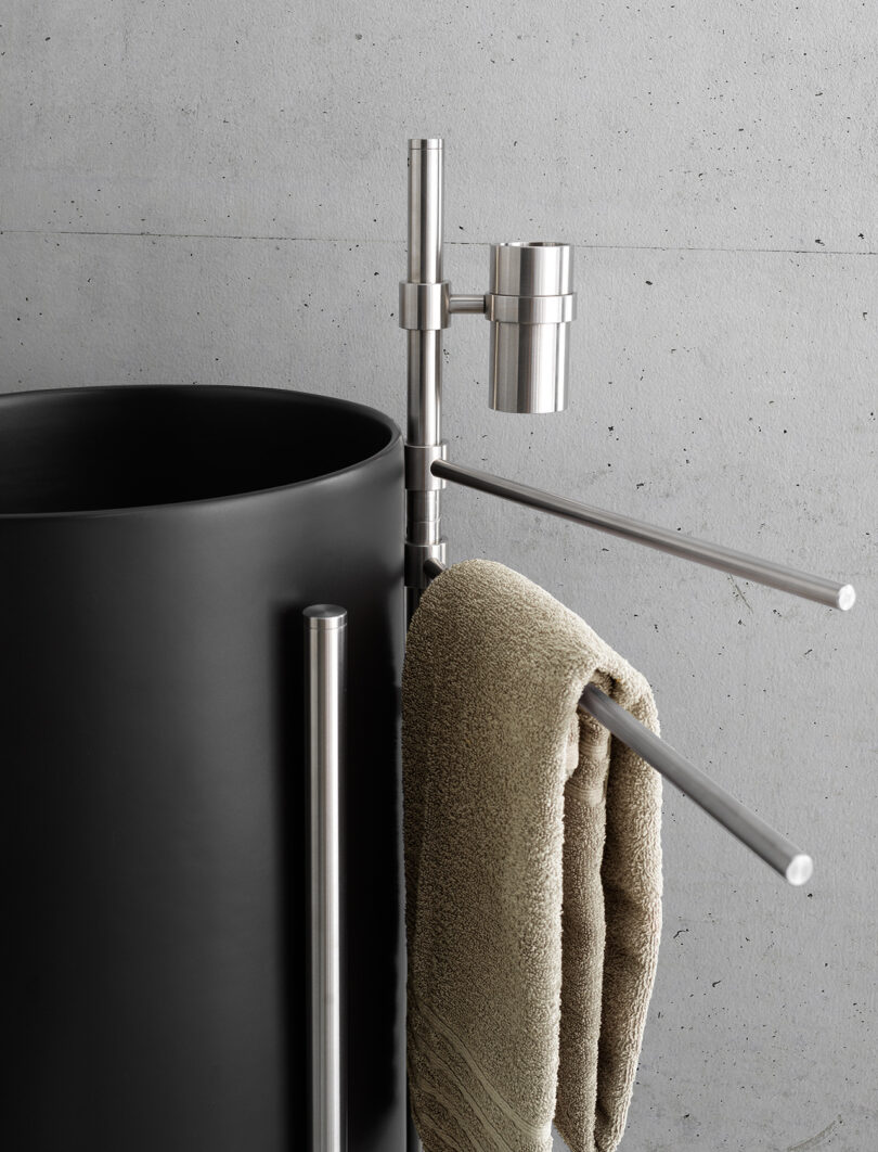 cylindrical black sink with attached towel holder